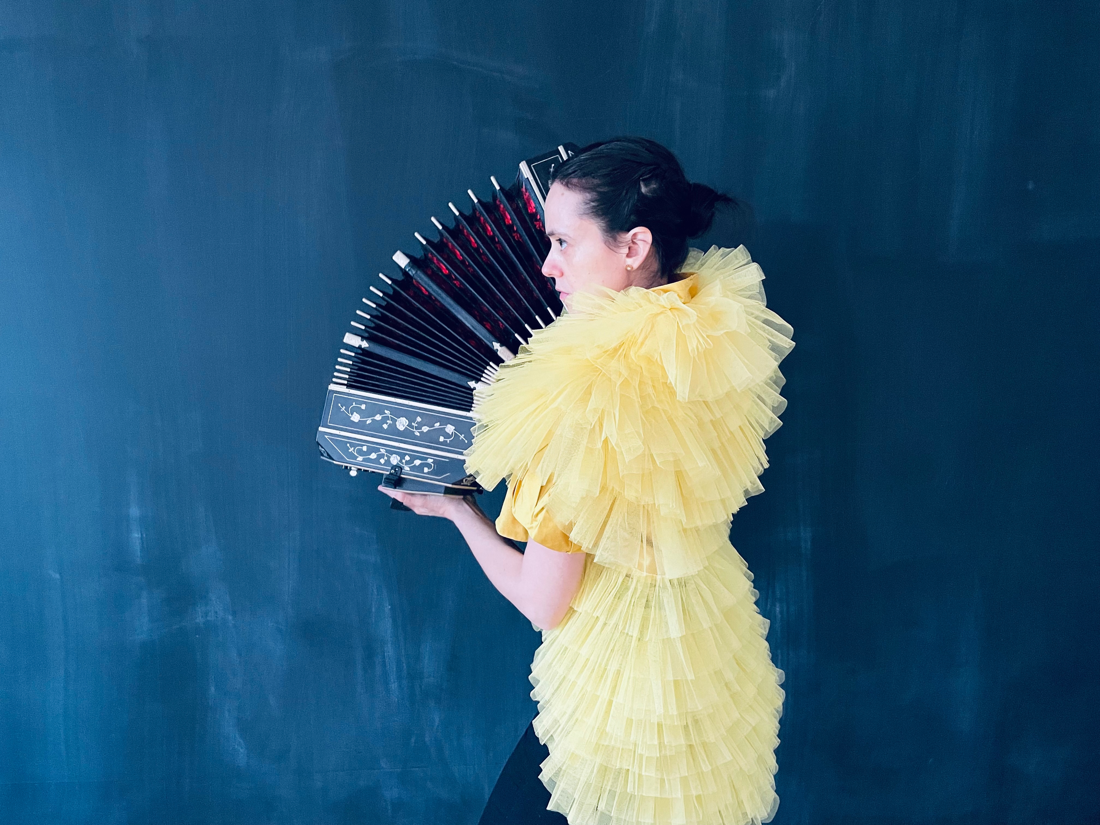 Woman with a bandoneon in a yellow dress